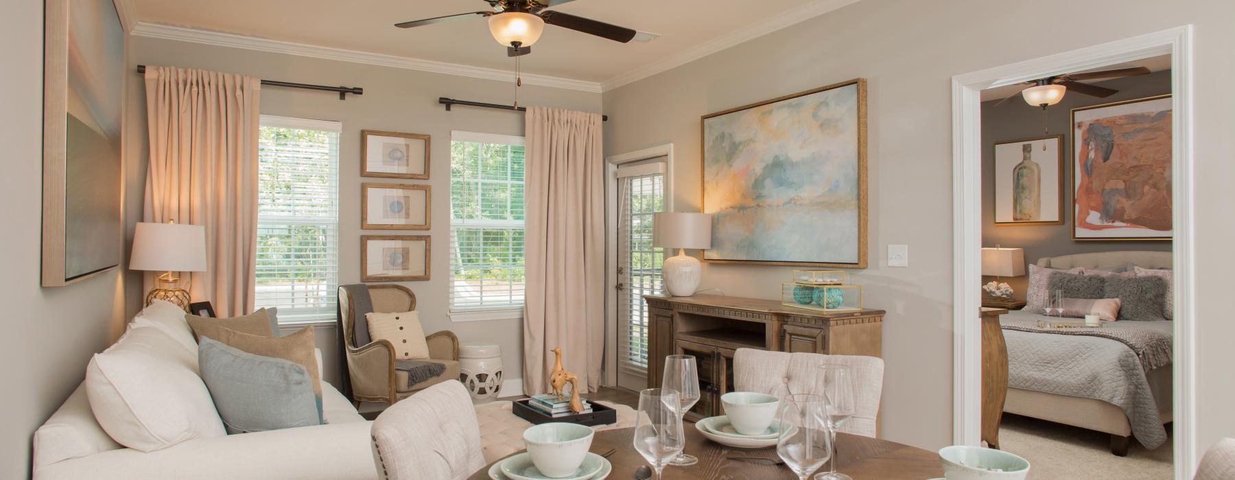 a living room with a large chandelier and a table with a white couch and a white